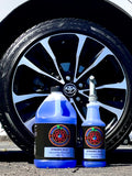 Two bottles of Dynamic Blue car care product in front of a Toyota car tire.